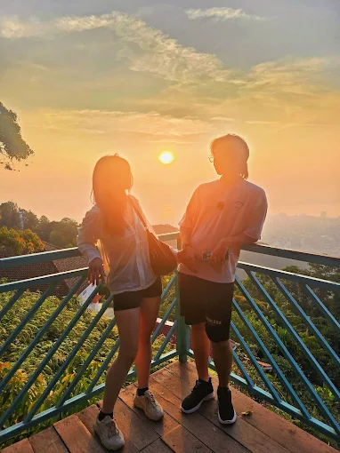 Couple watching the sunset over George Town from Penang Hill
