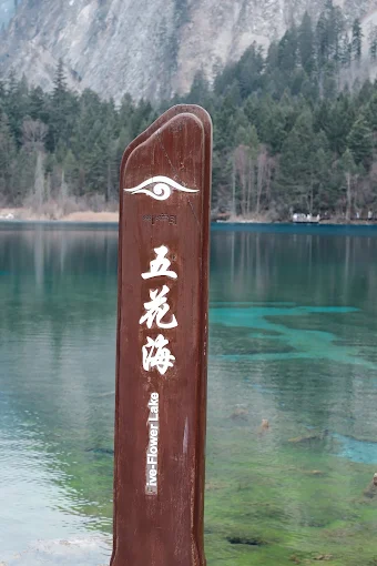 Five-Flower Lake sign at Jiuzhaigou with clear turquoise water behind