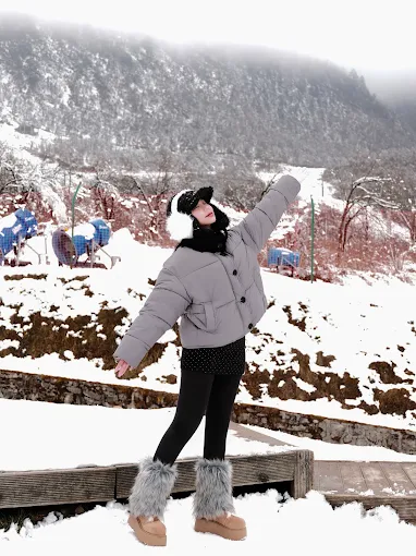 Traveler posing in winter gear at a snow resort
